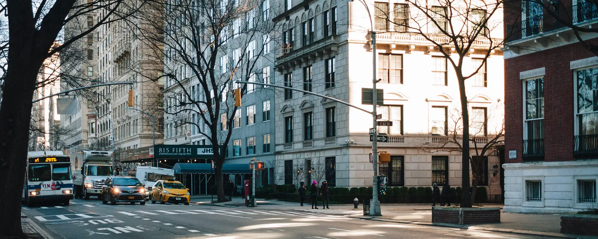A sunlit New York avenue lined with tall buildings