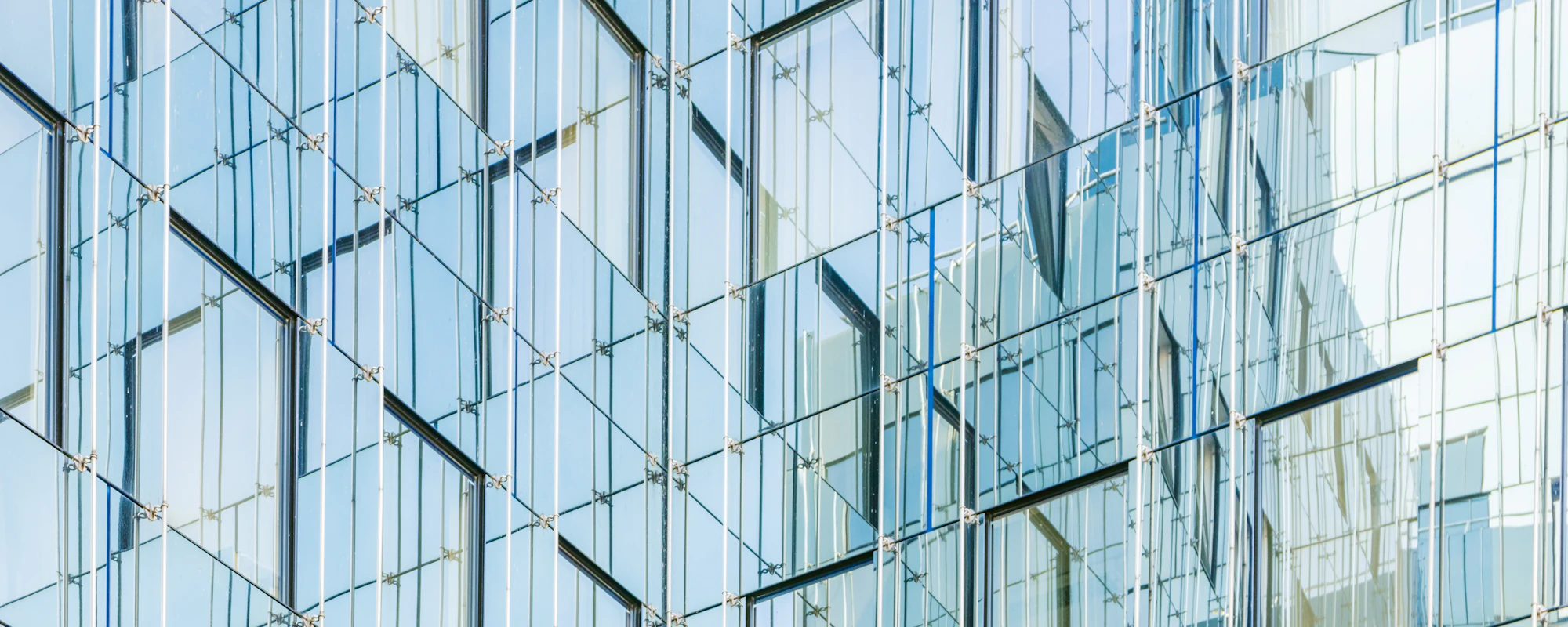 A layered glass facade reflecting the buildings around it